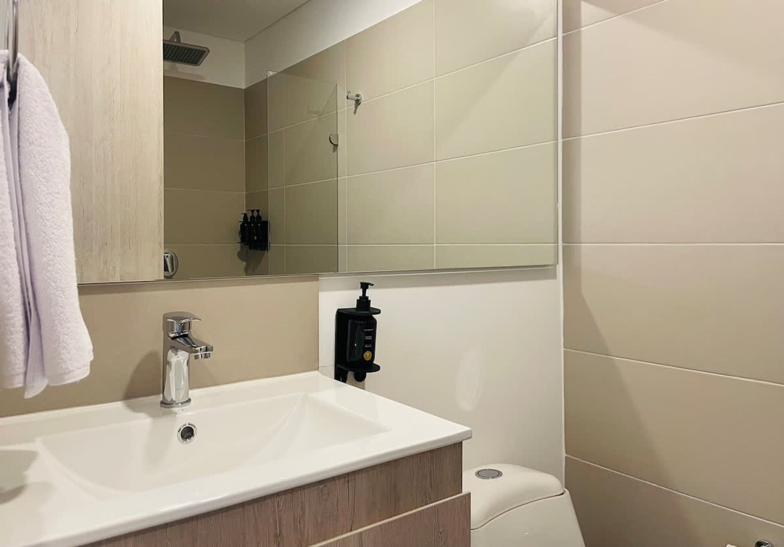Een badkamer met een witte wastafel, een spiegel en een toilet.