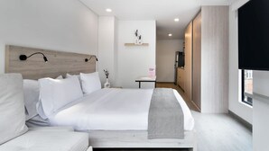 A modern hotel room with a large bed, a bedside table, a TV, and a window. - NOK Stylish Loft in Usaqu n (Bogotá)