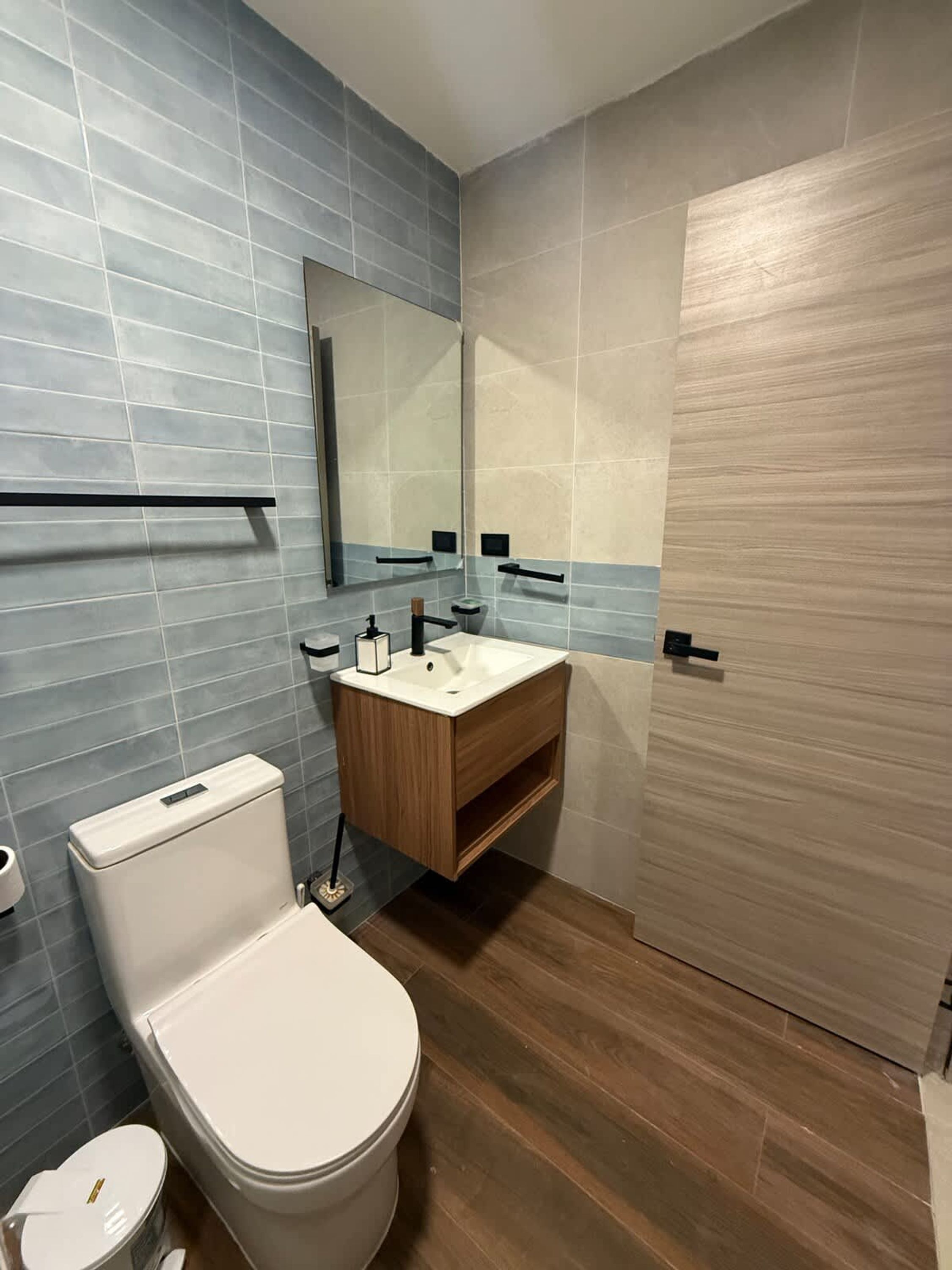 Ein modernes Badezimmer mit Toilette, Waschbecken und Spiegel.