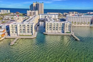 A waterfront hotel with multiple buildings, clear water, and a dock.
