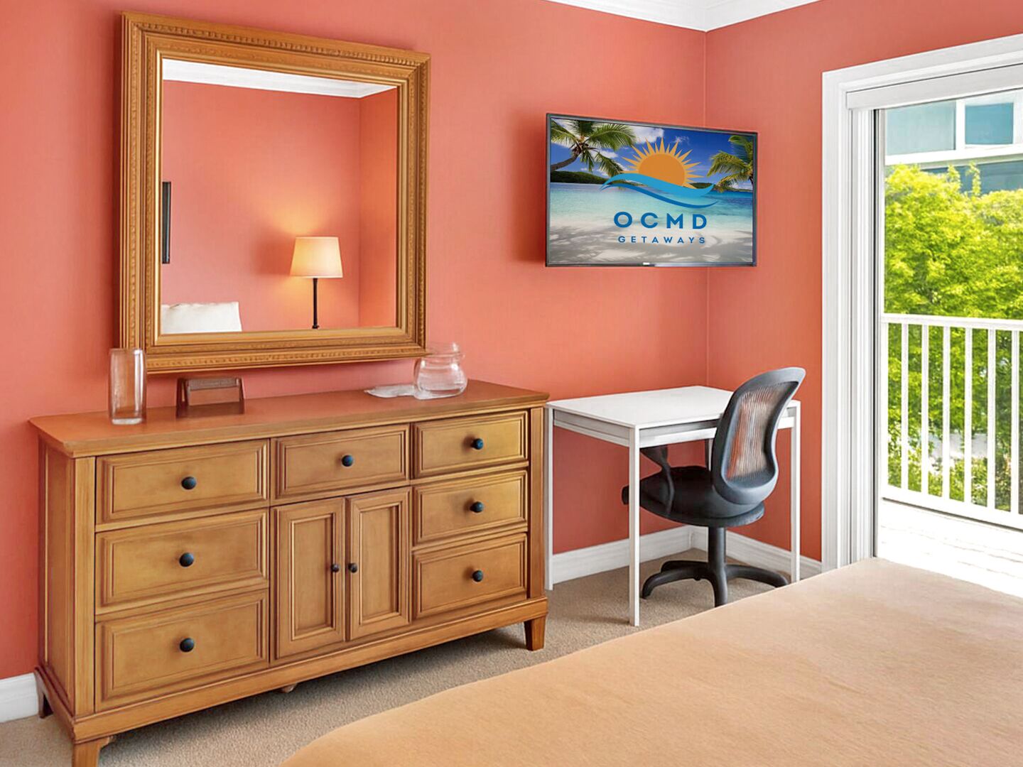 Quarto de hotel com cômoda de madeira, escrivaninha, cadeira, espelho grande e TV exibindo 'OCMD GETAWAYS' na parede.