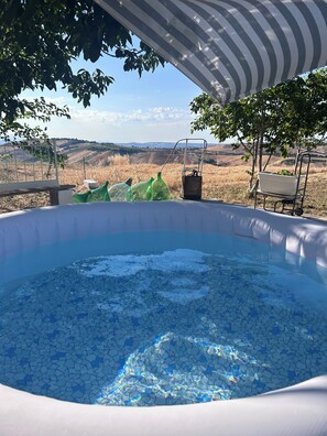 An outdoor hot tub with a view of rolling hills. - The Hill in a Room: A Typical Abruzzo Landscape Between the Majella and the Sea (Abruzzo)