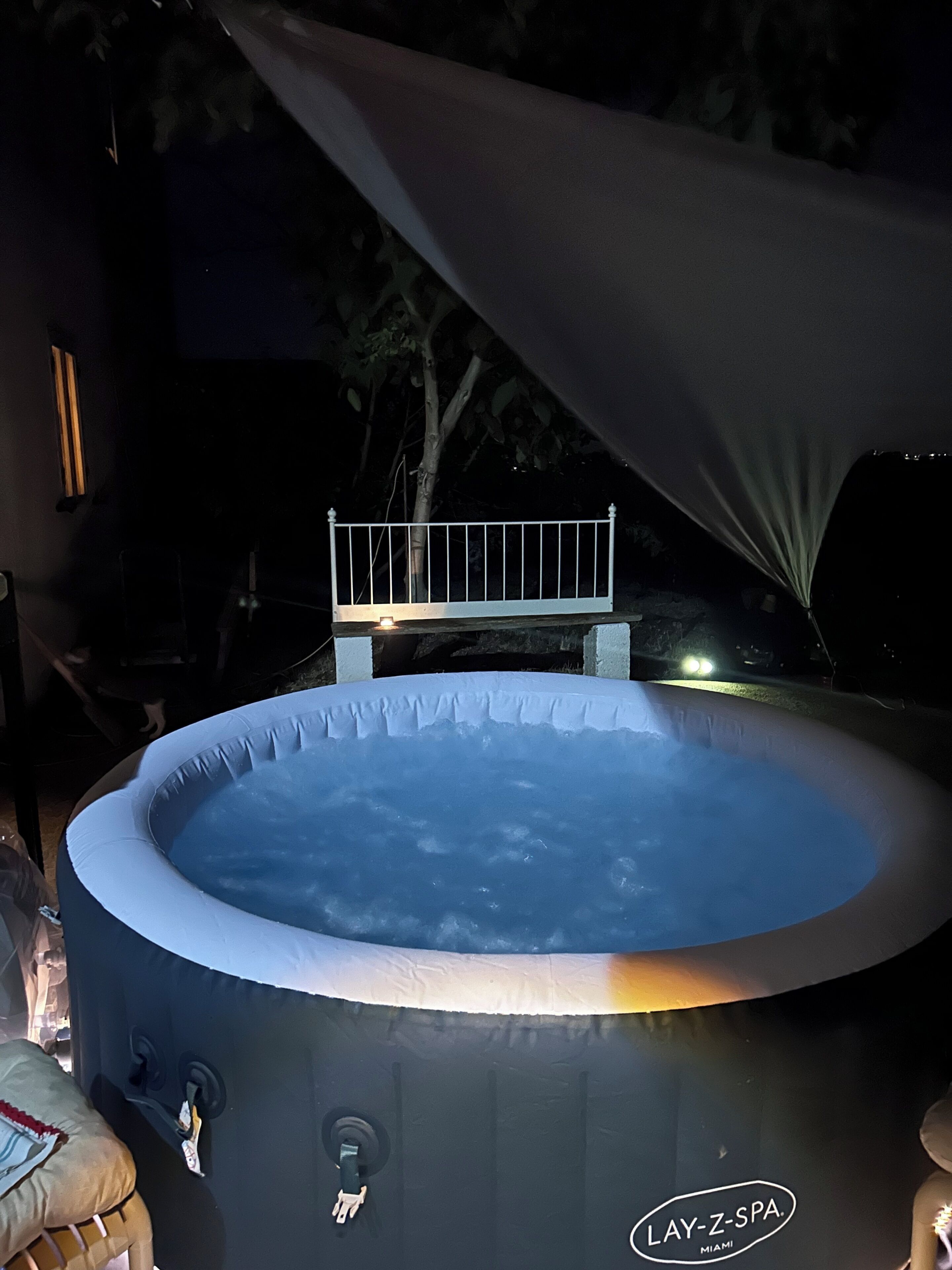 Una bañera de hidromasaje con baranda blanca, un panel de control y un logotipo que dice 'LAY-Z-SPA MIAMI'.