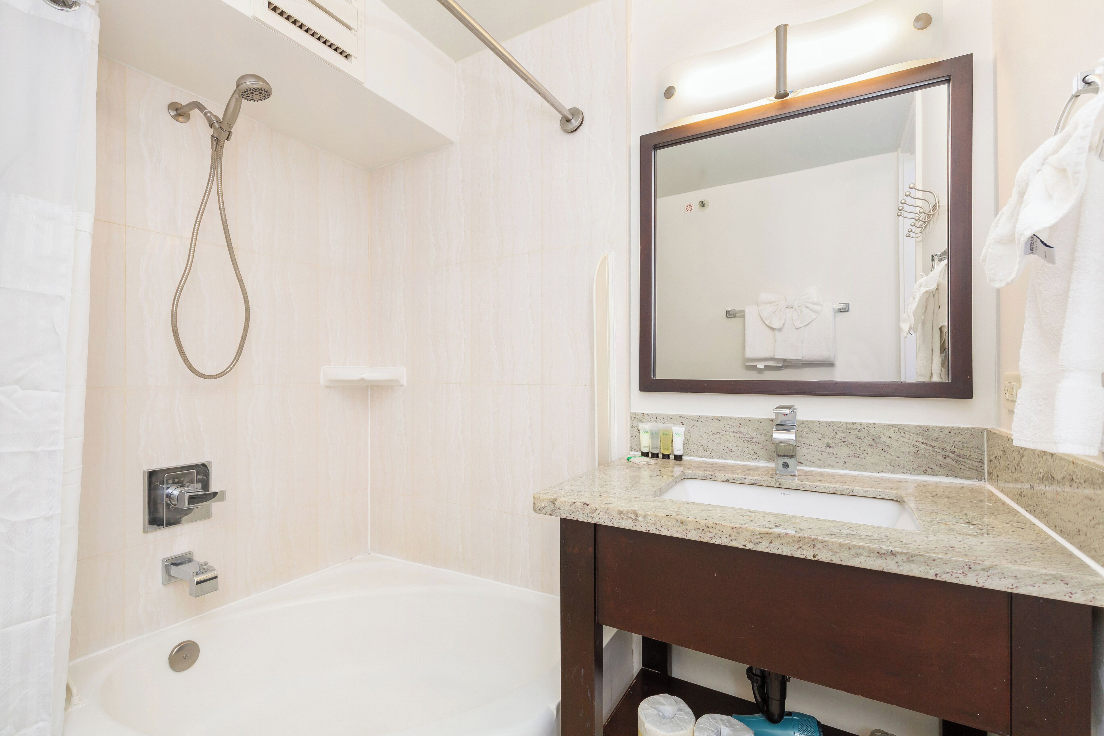 A modern bathroom with a bathtub, a shower, a sink, and a mirror.