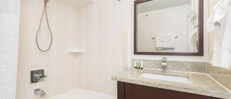 A modern bathroom with a bathtub, a shower, a sink, and a mirror.