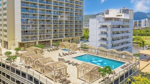A hotel with a rooftop pool, multiple balconies, and a view of the surrounding cityscape. - Diamond Head & Golf Course Views at Island Colony w/Amazing Amenities (Honolulu)
