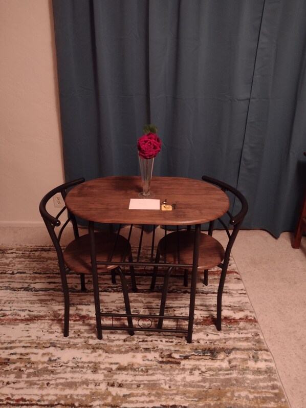 A round wooden table with a vase of pink flowers and a small card. - 
Peaceful Country Retreat – Only 16 Miles to Oregon Country Fair!
 (Eugene)