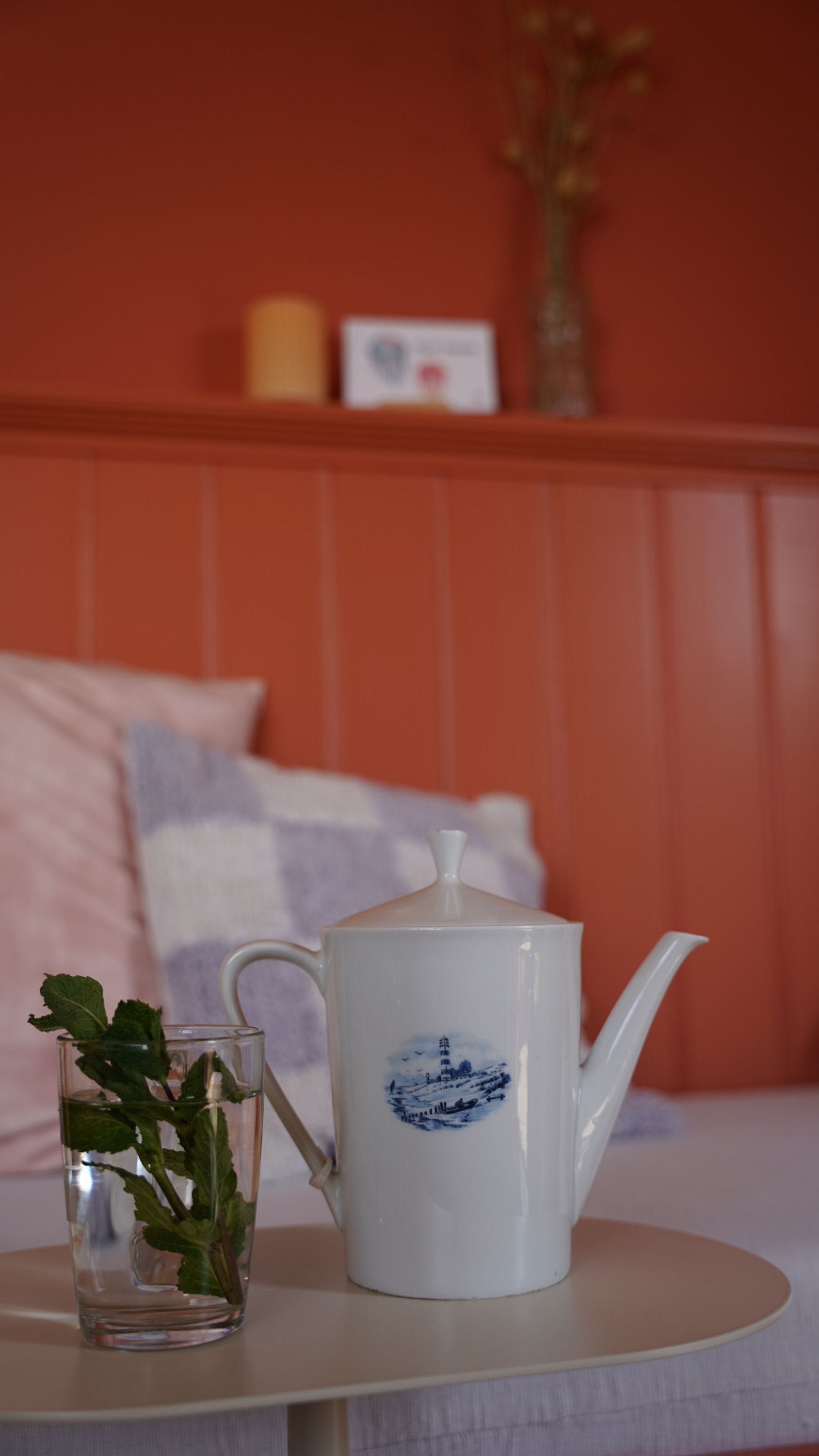 A white teapot with a blue design on a table.