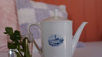 A white teapot with a blue design on a table.