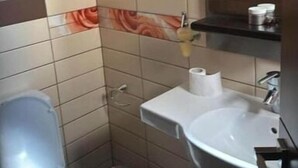 Une petite salle de bain avec des toilettes, un lavabo et une poubelle.