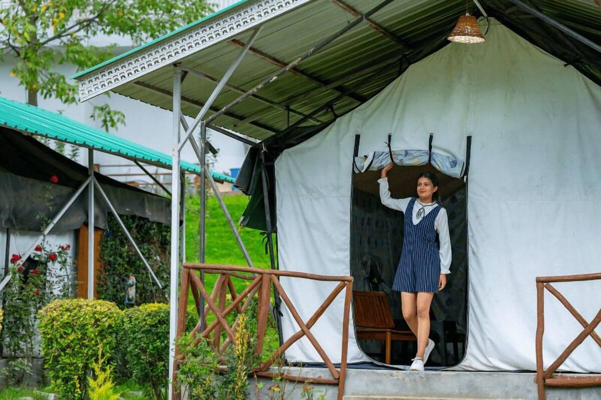 A person standing on a concrete platform under a tent-like structure with a metal roof.