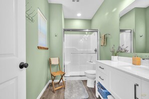 A bathroom with a shower, toilet, and sink.