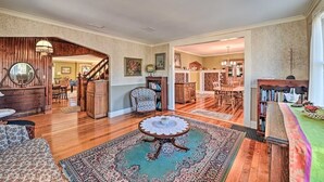 A spacious living room with a wooden staircase, a dining area, and a kitchen in the background. - 10 Mi To Gore Mountain: Home In Adirondack Park 5 Bedroom Home (Olmstedville)