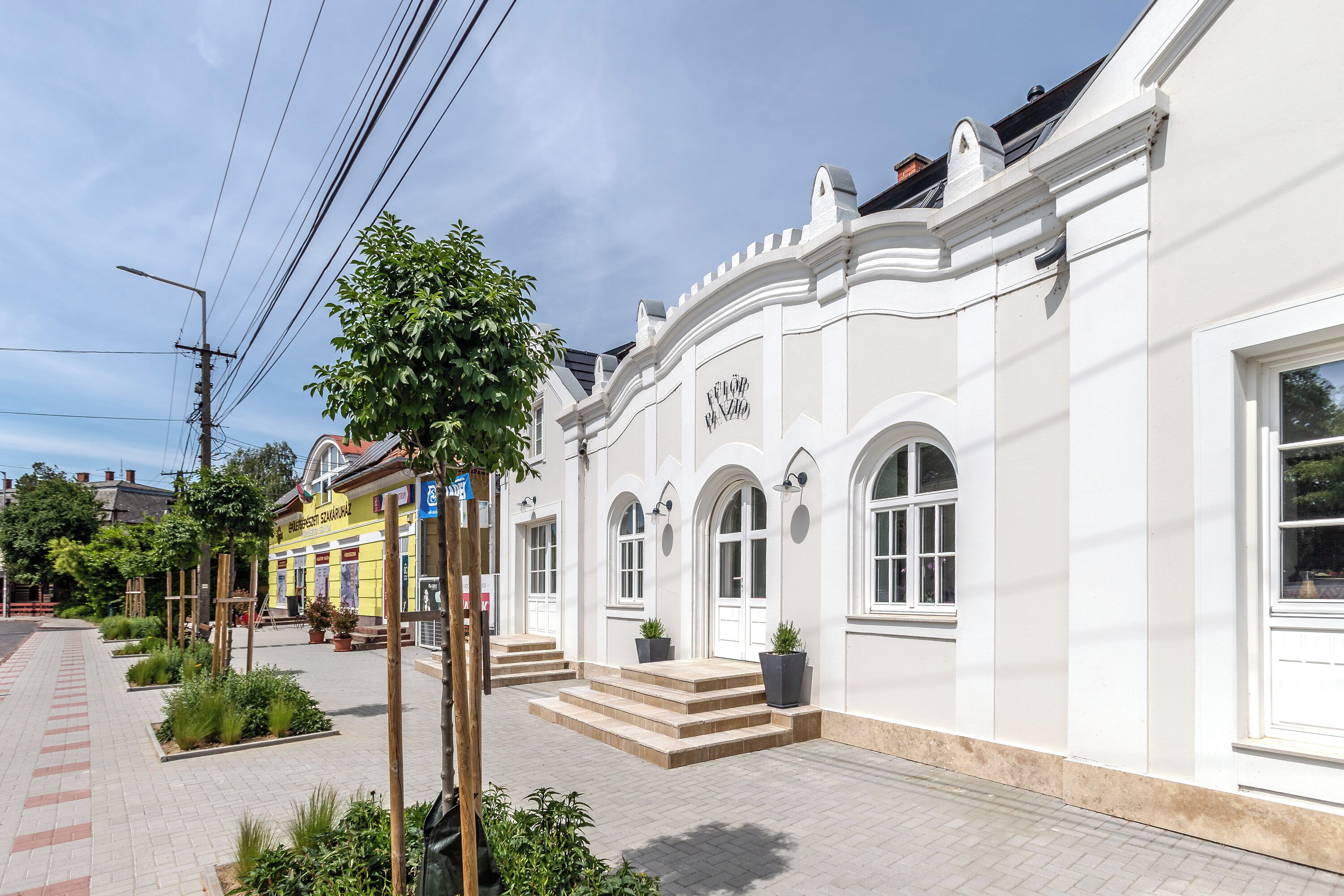 Un edificio blanco con ventanas arqueadas y un letrero que dice 'Hotel'.