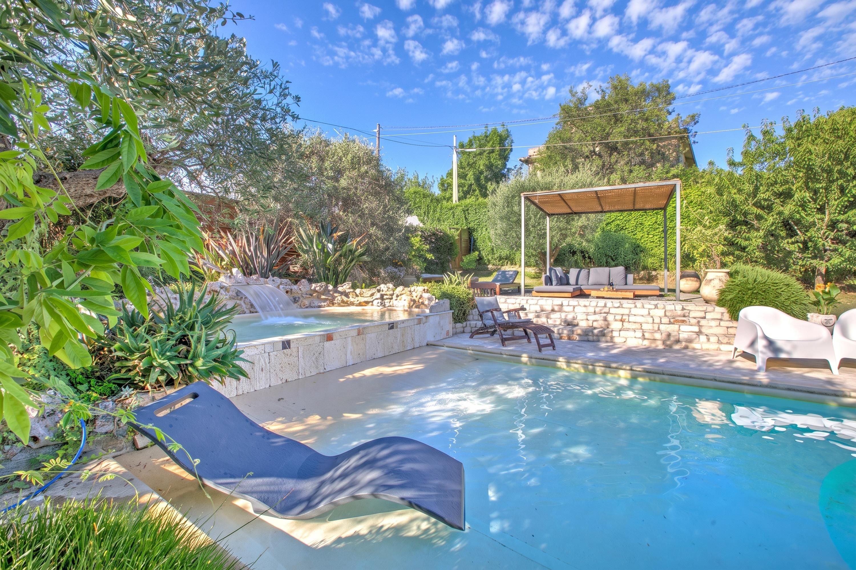 Piscina com hidromassagem, espreguiçadeiras e pérgola.
