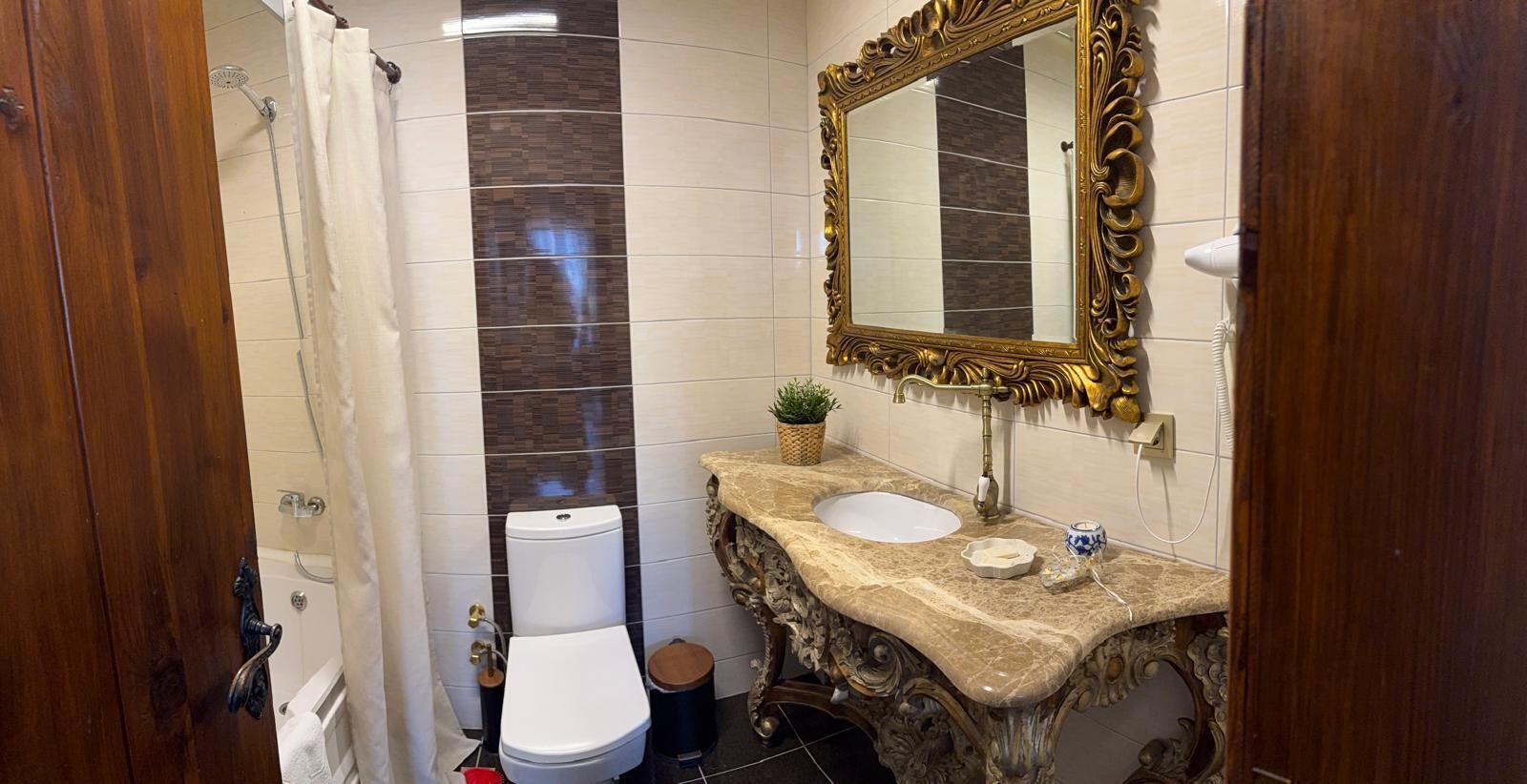 Een badkamer met toilet, wastafel en douche.