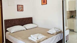 Une chambre d’hôtel avec un grand lit, une petite table de chevet et un miroir.