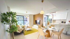 A modern apartment with a living room, dining area, and kitchen.