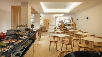 A modern dining area with a long counter, multiple tables, and chairs.