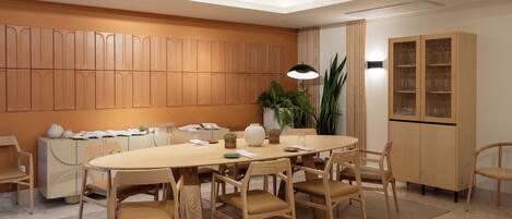 Un comedor moderno con una mesa redonda, sillas de madera, un aparador con puertas de vidrio y una planta en maceta.