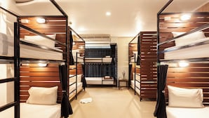 Ein Hotelzimmer mit Stockbetten, einem kleinen Tisch und einem Nachttisch.