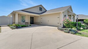 Une maison de plain-pied avec un garage, une porte d’entrée et une allée.