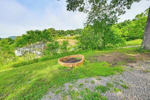 Um jardim bem cuidado com um canteiro de tijolos circulares, caminhos de brita e vegetação exuberante.