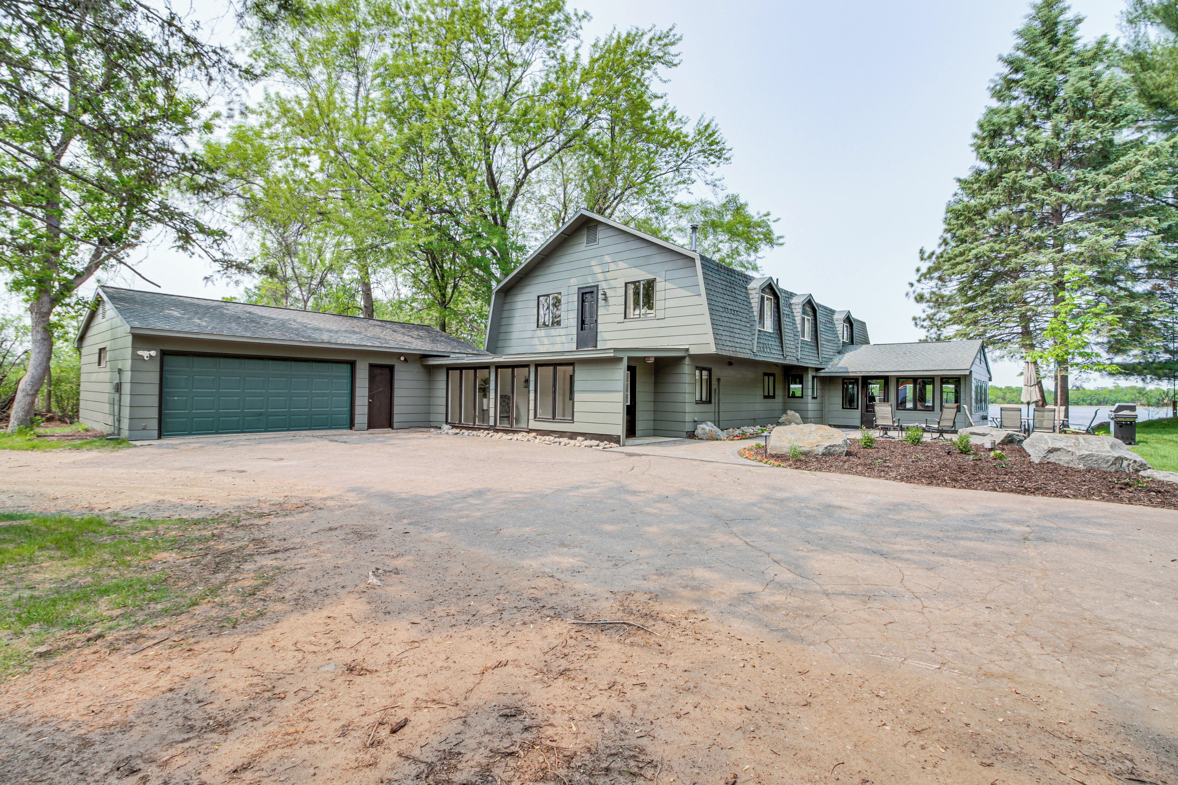 A two-story house with a garage, a covered porch, and a driveway.