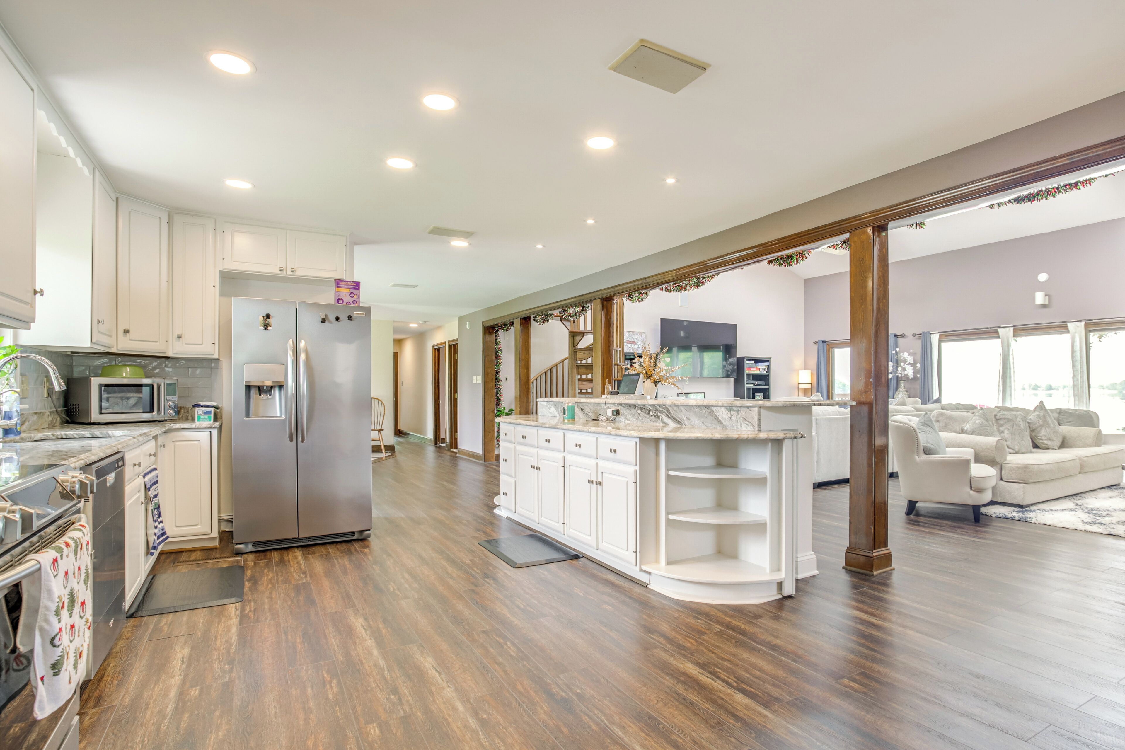 A spacious kitchen with white cabinets, a large island, and a built-in microwave.