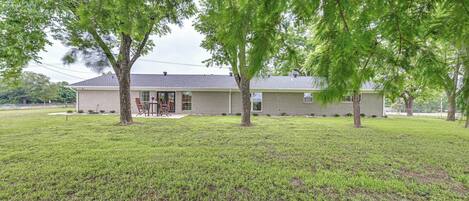 A single-story house with a brick exterior, a front porch, and a lawn.