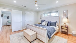 Un dormitorio con cama, mesita de noche y ventana.