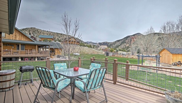 A wooden deck with a table and chairs, overlooking a fenced yard and mountains. - Rustic Cabin Near Palisade State Park w/ Deck! (Sterling)