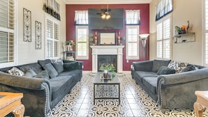 A living room with two sofas, a fireplace, and patterned floor tiles. - Golf, Fish & More: Cozy Safari Unit in Atwater! (Atwater)