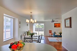 A dining area with a table set for four, a chandelier, and a view of the backyard through glass doors. - Central Tacoma Escape < 2 Mi From The Tacoma Dome! (Tacoma)