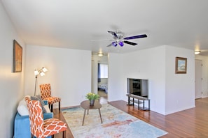 Ein Wohnzimmer mit Deckenventilator, Fernseher und Kamin.