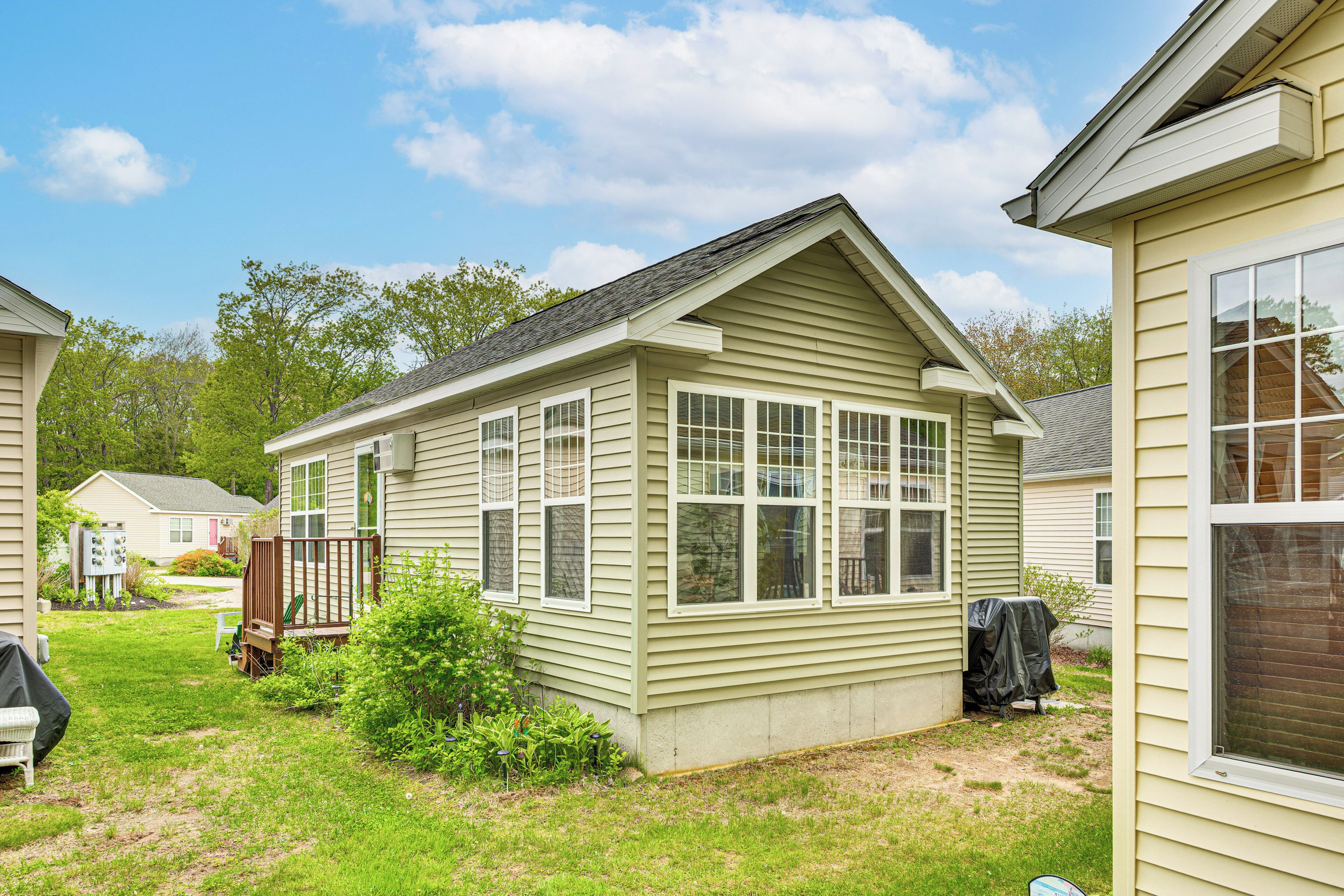 A single-story house with a sloped roof, a front deck, and a covered patio area.