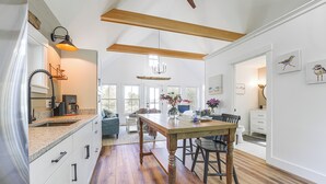 A spacious kitchen with wooden flooring, a large island, and a dining area with chairs. - Oceanfront Studio w/ Private Dock in Harpswell! (Harpswell)