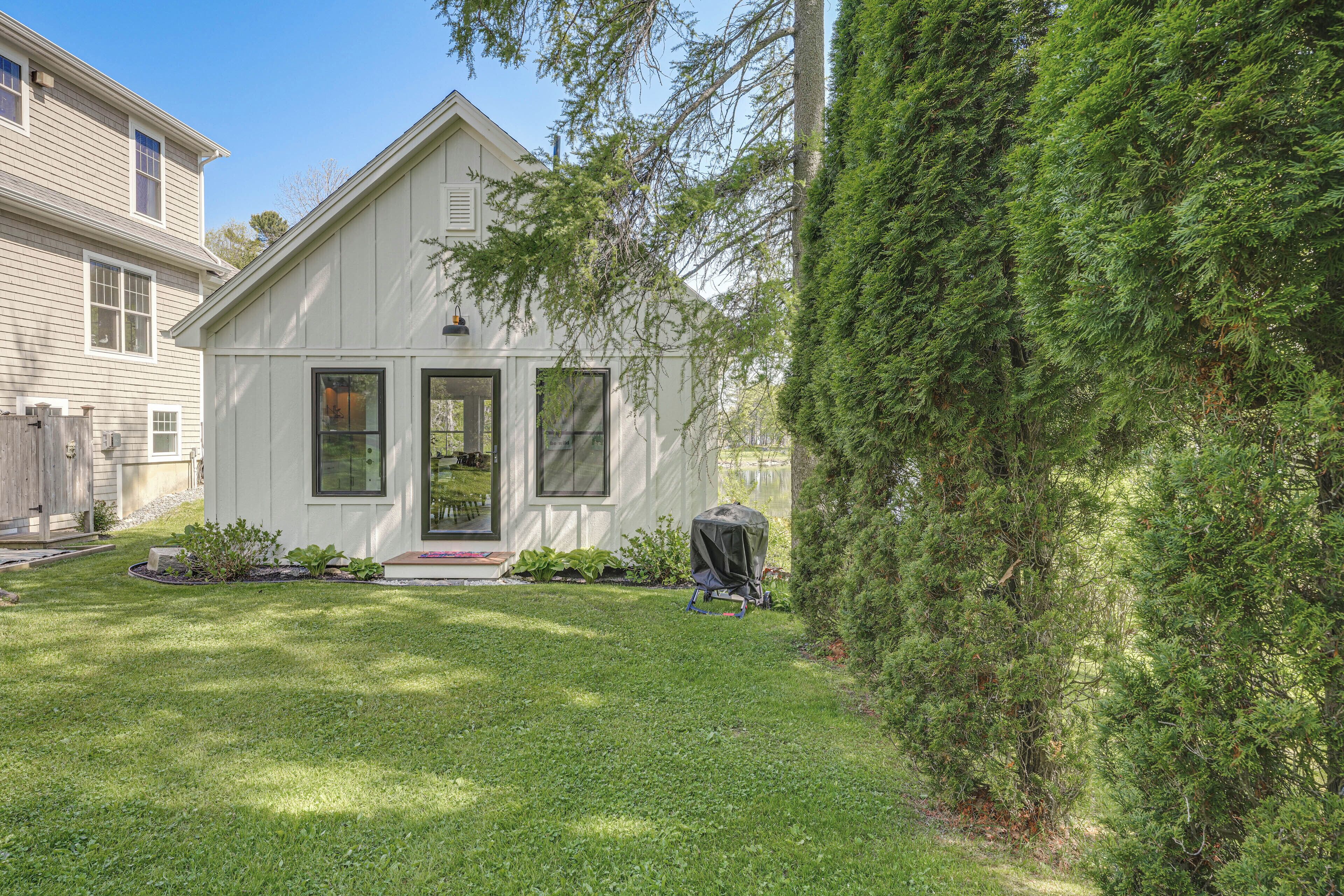 A two-story house with a front porch, a covered patio, and a well-maintained lawn.