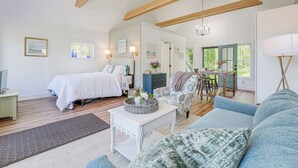 A spacious living area with a large sofa, a dining table, and a separate bedroom with a bed. - Oceanfront Studio w/ Private Dock in Harpswell! (Harpswell)
