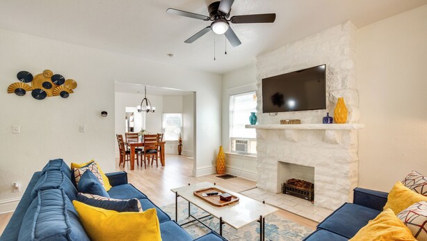 A modern living room with a blue sofa set, a fireplace, a flat-screen TV, and a ceiling fan. - Modern 2BR Kansas City Condo Near Downtown (Kansas City)
