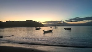 A beach scene with boats on calm water during sunset. - Pousada Maresia Buzios (Buzios)