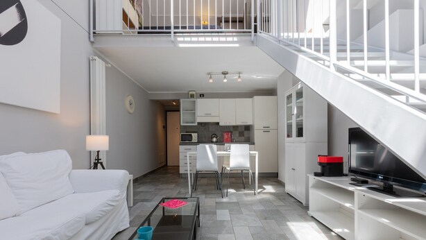 Un apartamento moderno con sala de estar, comedor, cocina y balcón.