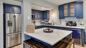 A modern kitchen with stainless steel appliances, blue cabinets, and a marble island. - Fall Foliage, Hiking Trails, Close to Jim Thorpe! (Lake Harmony)