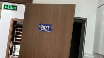A wooden door with a sign reading "601" and an air conditioning unit above it.