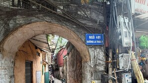 Un callejón estrecho con un muro de ladrillo, un letrero que dice 