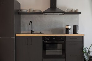 Een moderne keuken met een ingebouwde oven, een koffiezetapparaat en een spoelbak.