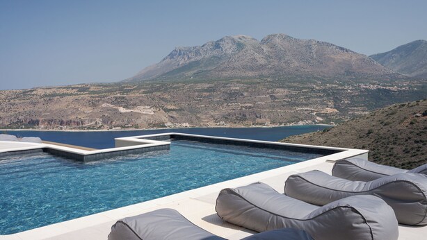 An infinity pool with a view of mountains and a body of water. - The One Limeni (Areopoli)