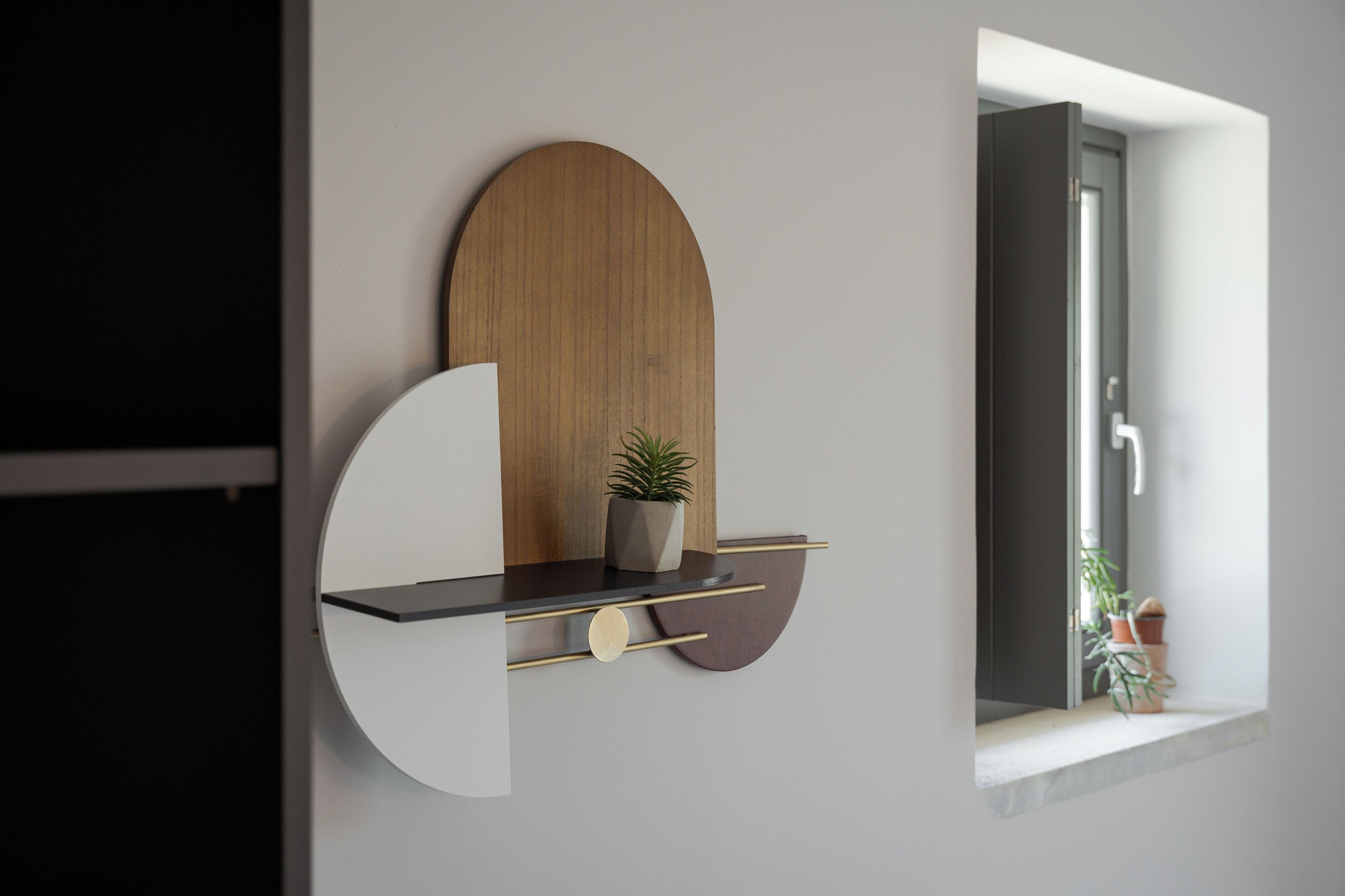 Un interior moderno con un diseño de estantería minimalista, una pared de acento de madera y vistas al exterior.