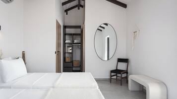 Une chambre à coucher moderne avec un grand lit, une chaise, un banc, une armoire et un miroir.