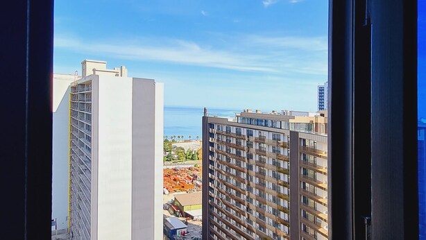 Ein Hochhaus mit Blick auf den Ozean und weitere Gebäude in der Ferne.